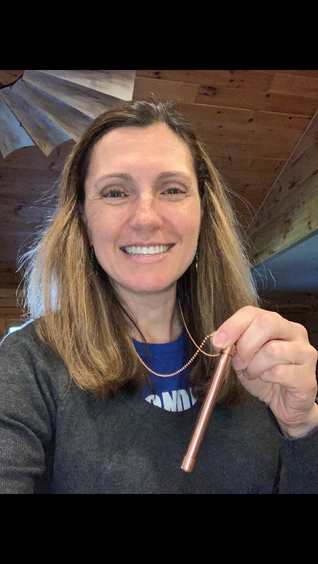 Shows lady wearing One 4" Magic Wand Halo Necklace on 30" beaded ball copper chain treated so it will not turn her neck green. Made in USA from natural antimicrobial copper. Roll between hands to kill 99.97% of bacteria, virus, and germs. All Natural Hand Sanitizers, Chemical Free, Lasts Forever. Will not chap hands or make sore. Recyclable. EPA registered. Patented