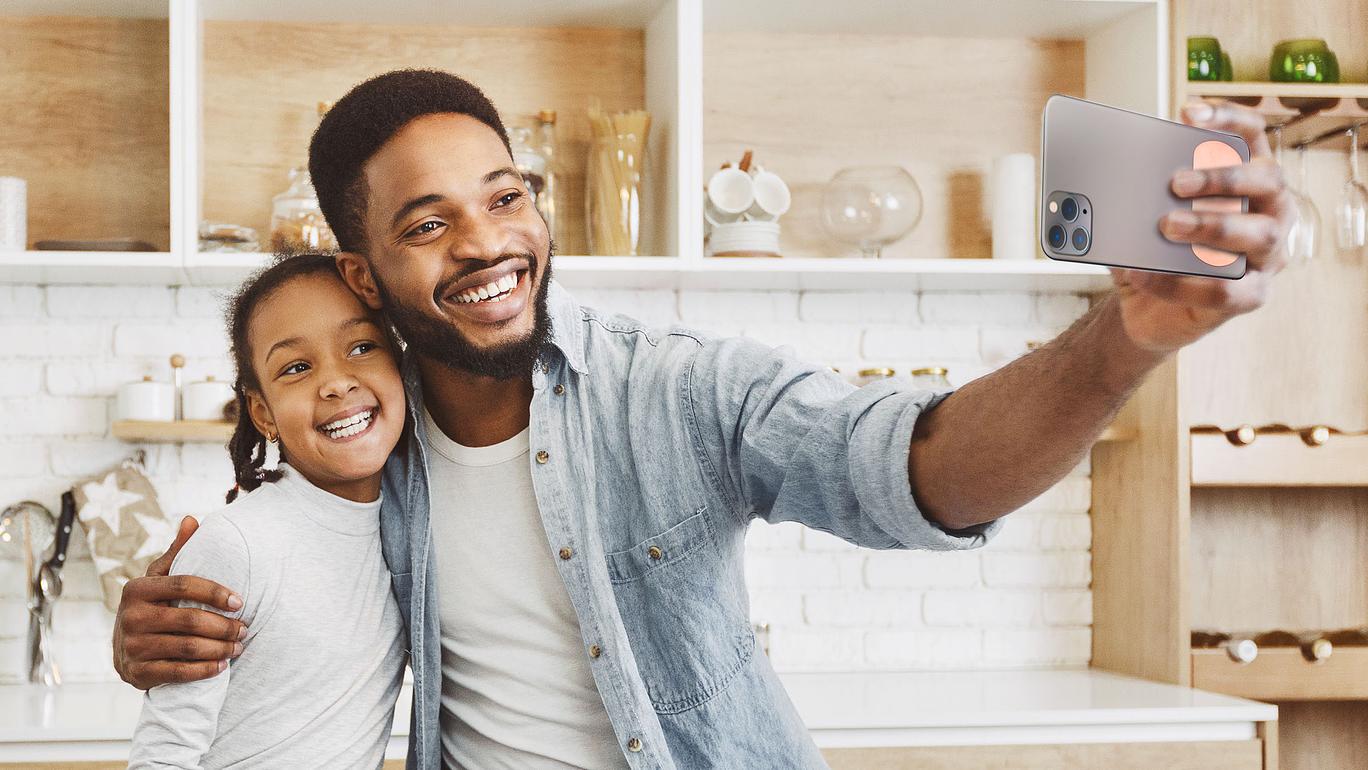 Father taking selfie with his daughter while holding phone case with 2" x 1.5" Adhesive Phone Patch made in USA from natural antimicrobial copper attaches to germy devices we touch most. Sanitizers, Chemical Free, Lasts Forever. Recyclable. Kills 99.9% of Harmful Bacteria. EPA registered.