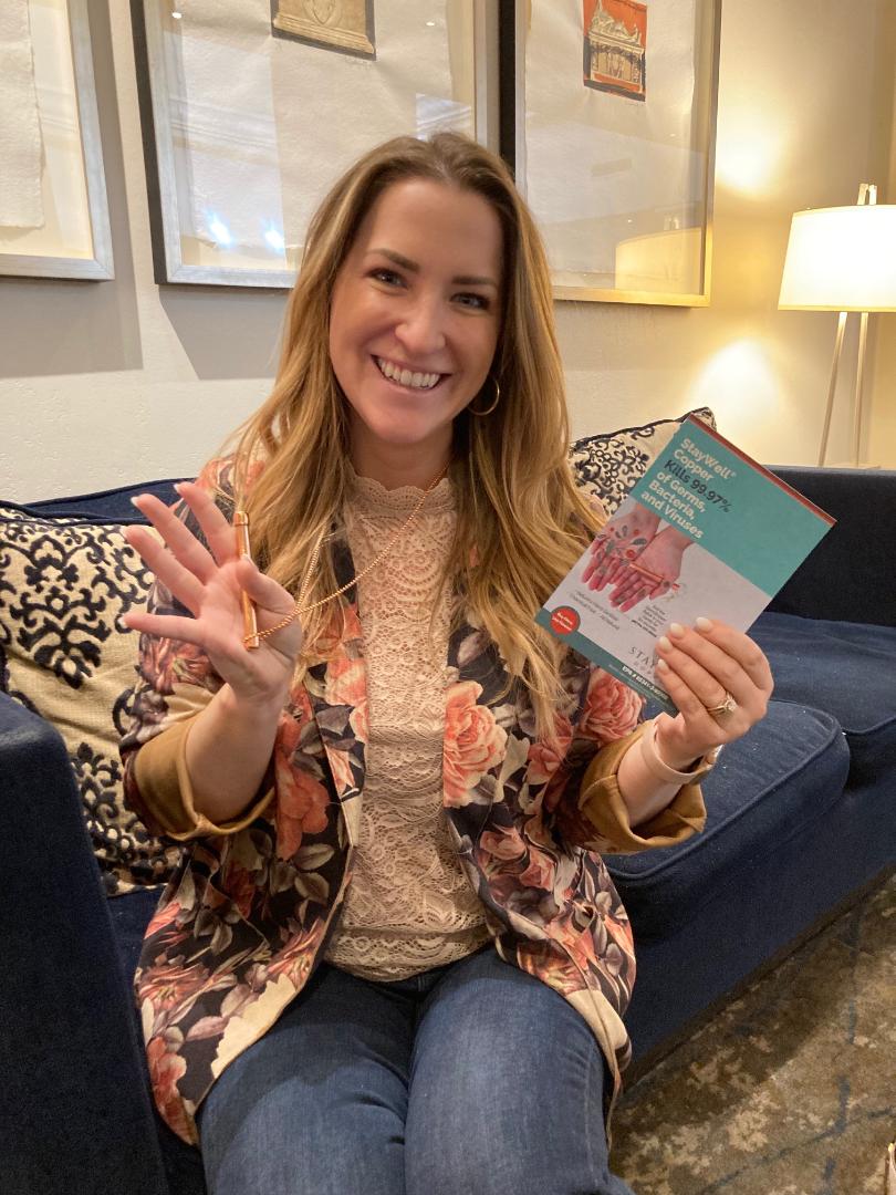 Woman holding her Germ killing StayWell Copper Halo Necklace