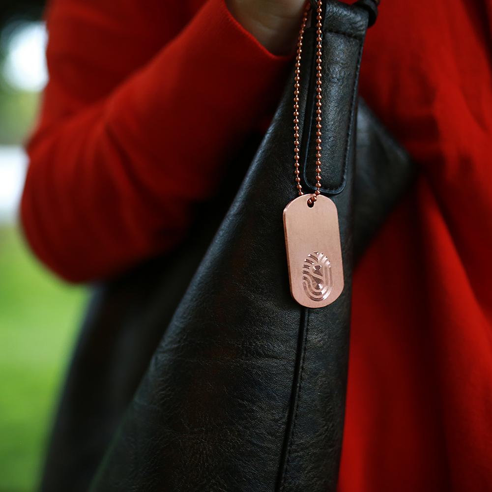 Antimicrobial Copper DogTag Charm on a 6” copper ball chain made in USA from natural antimicrobial copper attached to a purse handle. This shows close up. All Natural Hand Sanitizers, Chemical Free, Lasts Forever. Will not chap hands or make sore. Recyclable. Kills 99.9% of Harmful Bacteria. EPA registered. 