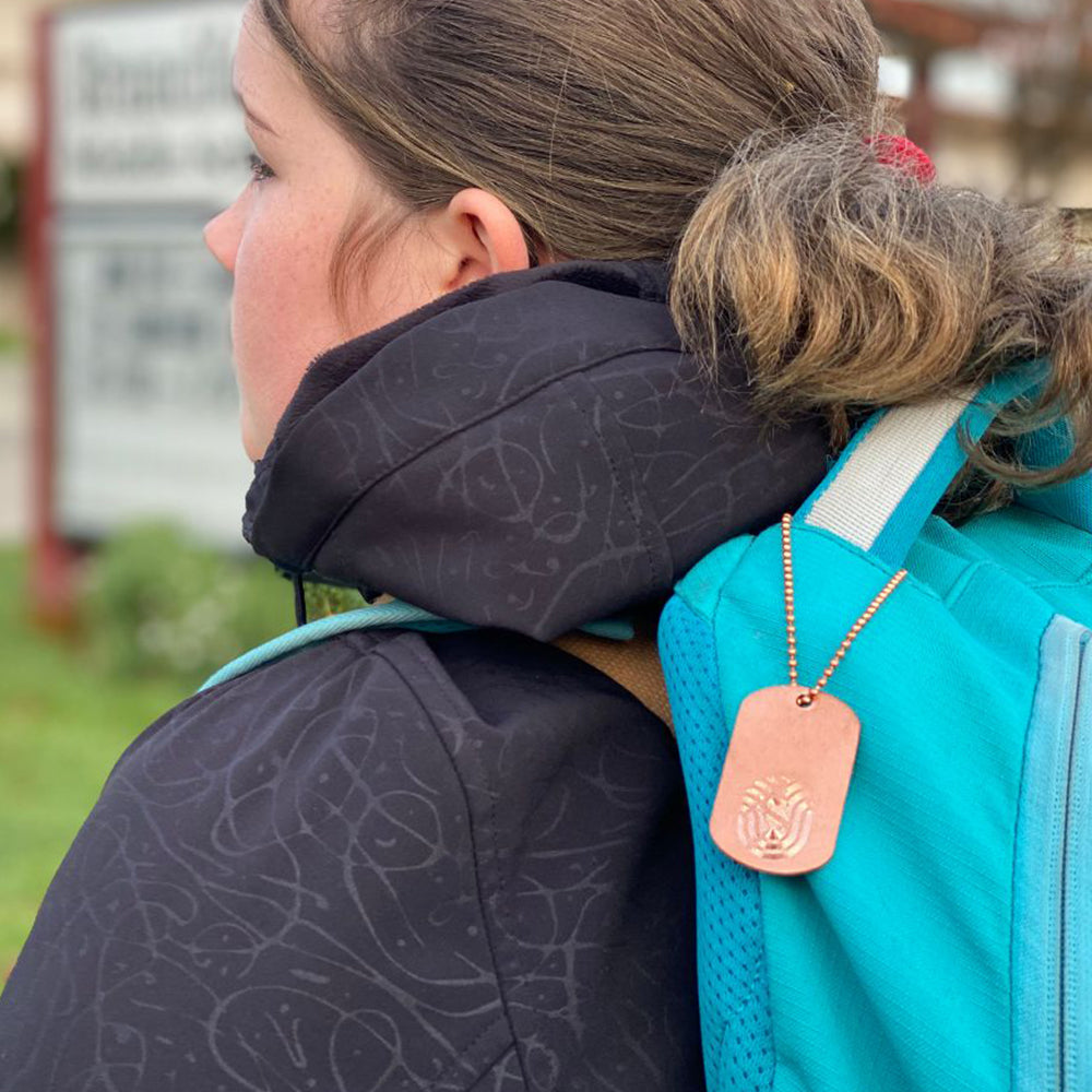 Antimicrobial Copper DogTag Charm on a 6” copper ball chain made in USA from natural antimicrobial copper attached to student backpack. All Natural Hand Sanitizers, Chemical Free, Lasts Forever. Will not chap hands or make sore. Recyclable. Kills 99.9% of Harmful Bacteria. EPA registered. 